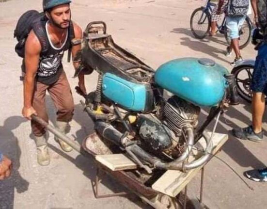 Cubano acude al servicentro con su moto encima de una carretilla para comprar gasolina